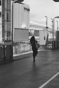 a black and white photo of a woman walking down a street